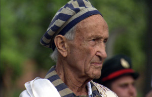 Ed Mosberg wearing the Tallit in Birkenau whilst listening to the Hatikva